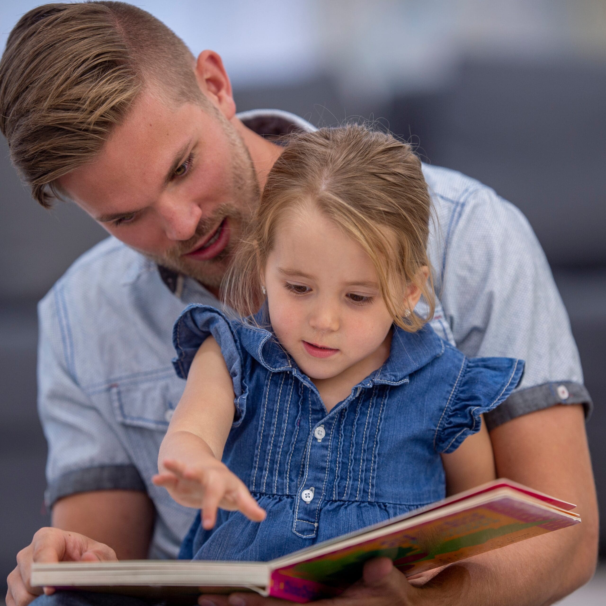 Parent reading a picture book with a young child to build expressive language skills