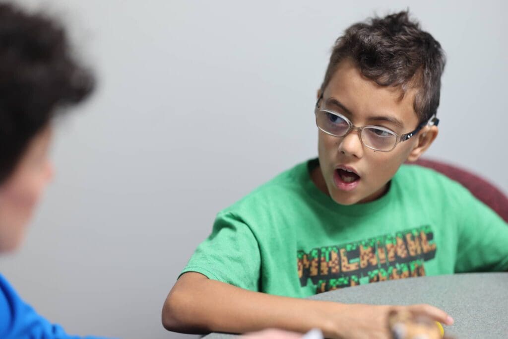 A young boy with an oral motor deficit works on oral motor function with a Speech Pathologist at Bliss Speech and Hearing Services.