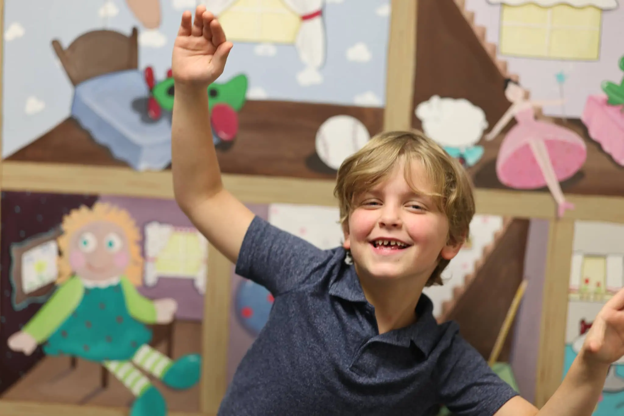 A young boy waving in a room at Bliss Speech and Hearing Services during speech therapy services