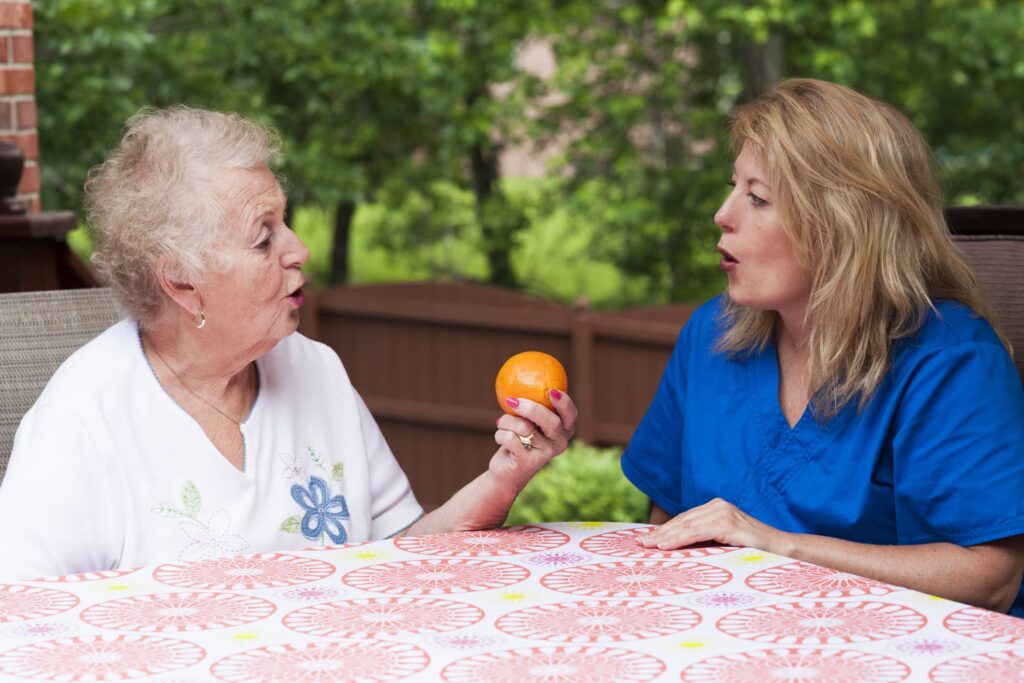 An adult woman with a traumatic brain injury working on her speech with a Bliss Speech and Hearing Services professional.