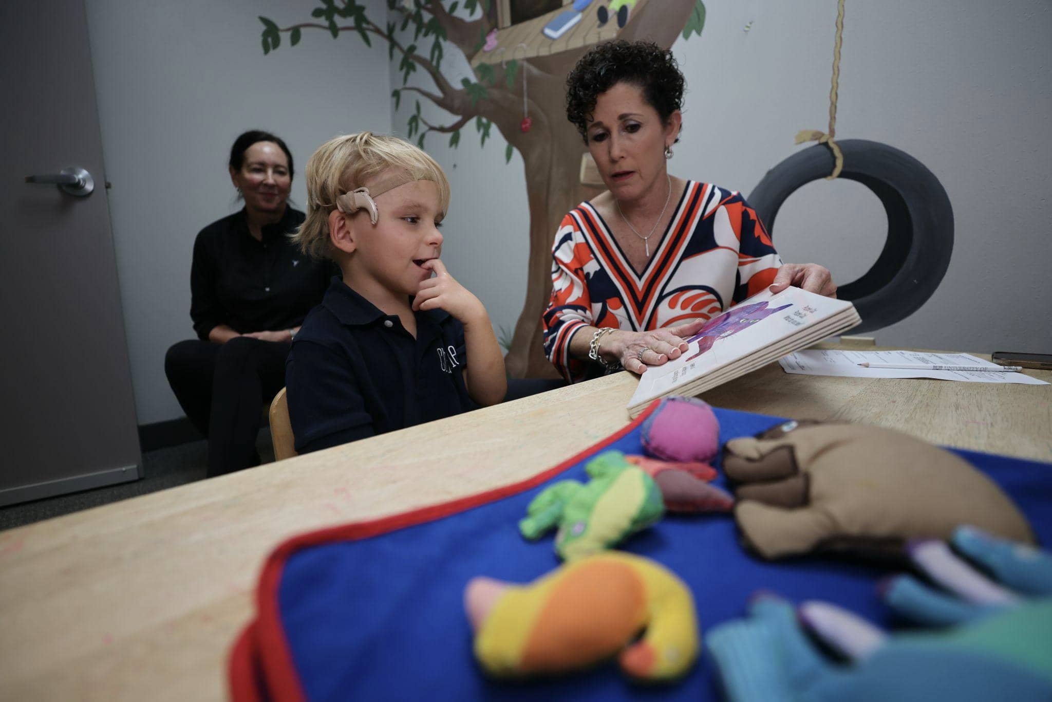 A young boy with cochlear implants works on auditory skills with anAuditory-Verbal Therapist at Bliss Speech and Hearing Services.